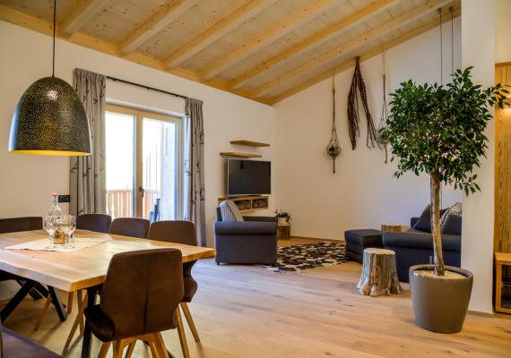 Living room with wooden ceiling and dining table that creates a cozy and inviting atmosphere