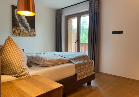 Schlafzimmer mit Holzbetten im alpinen Chalet in Lärche, Südtirol Alm Lodges