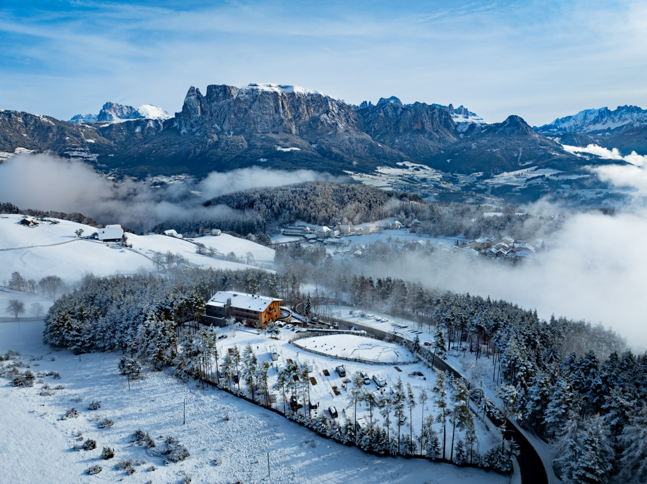 Winterliche Berglandschaft mit Schnee, einem Haus und einer Straße in der Schartneralm