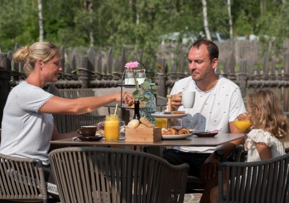 A family enjoys breakfast at an outdoor table